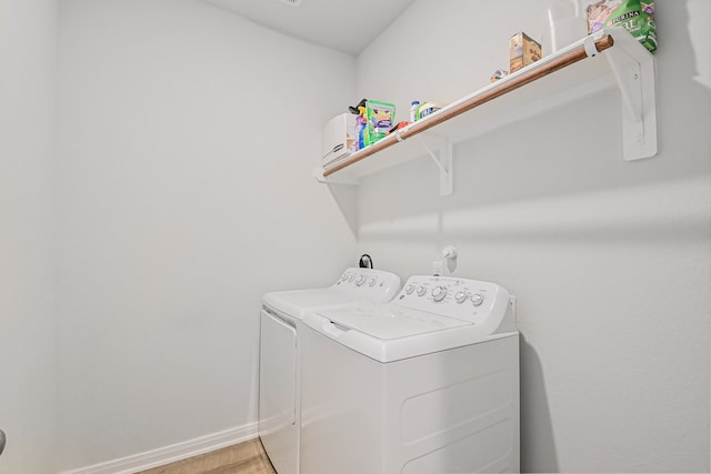 clothes washing area featuring washer and clothes dryer and light hardwood / wood-style flooring