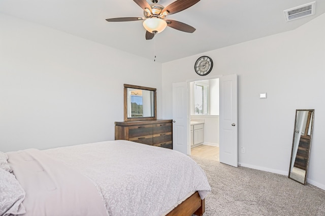 carpeted bedroom with ceiling fan and ensuite bath