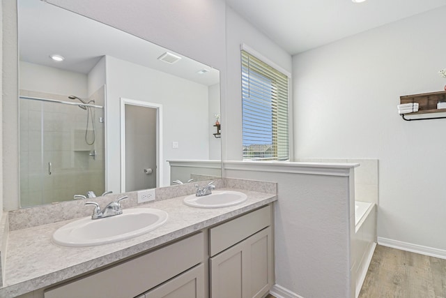 bathroom featuring wood-type flooring, shower with separate bathtub, and vanity