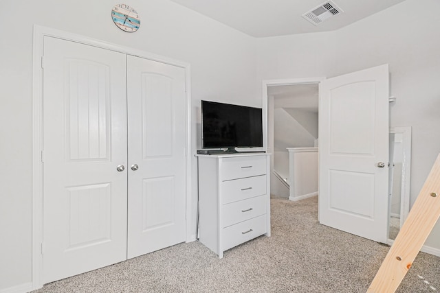 unfurnished bedroom featuring light carpet and a closet