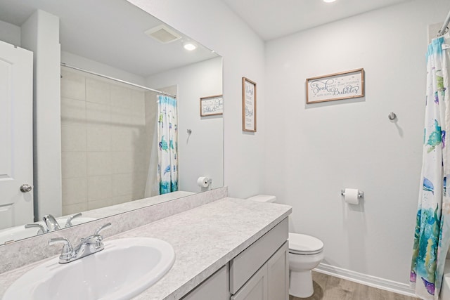 bathroom with wood-type flooring, a shower with curtain, vanity, and toilet