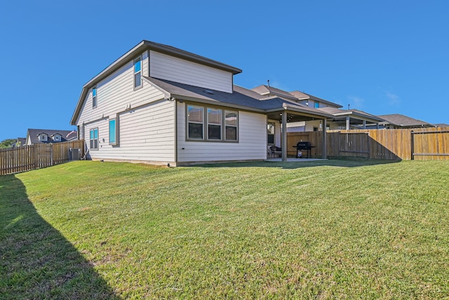 rear view of house featuring a yard and a patio area