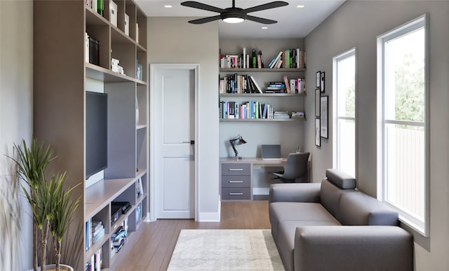 office area featuring ceiling fan, light hardwood / wood-style floors, and built in desk