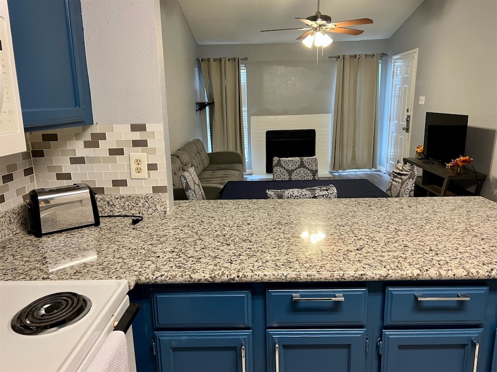 kitchen with blue cabinetry, decorative backsplash, and ceiling fan