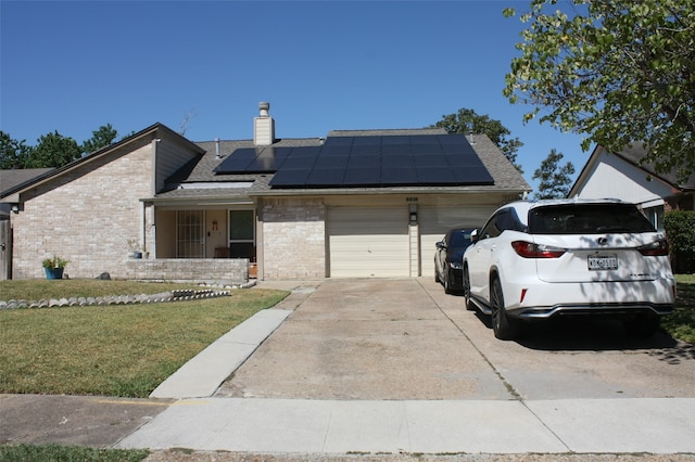 view of front of house featuring a garage, a front lawn, and solar panels