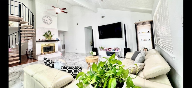 living area with visible vents, a premium fireplace, marble finish floor, a textured ceiling, and beam ceiling