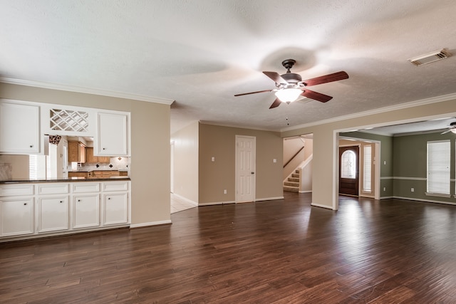 unfurnished living room with ceiling fan, ornamental molding, plenty of natural light, and dark hardwood / wood-style flooring