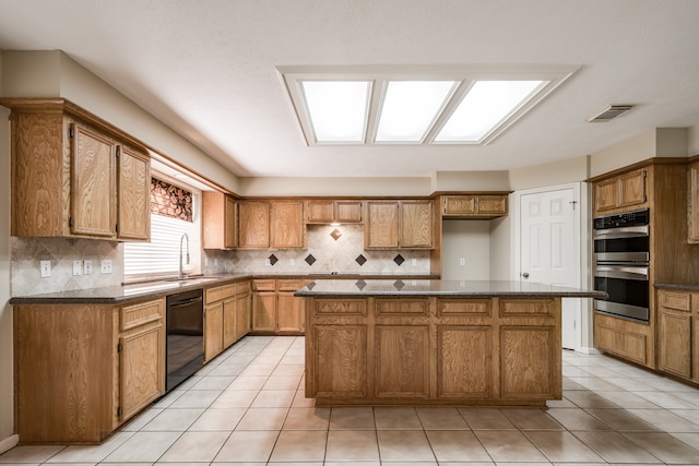 kitchen with black dishwasher, light tile patterned floors, double oven, and a kitchen island