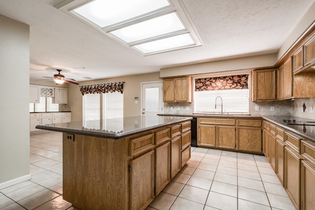 kitchen with backsplash, a center island, ceiling fan, and a wealth of natural light