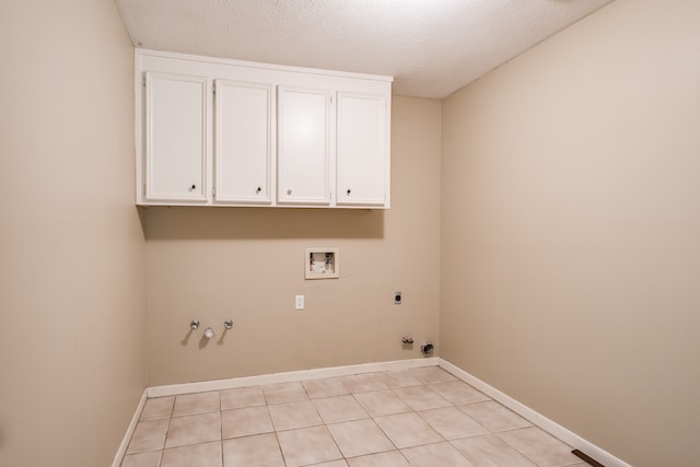 clothes washing area featuring washer hookup, gas dryer hookup, a textured ceiling, cabinets, and electric dryer hookup