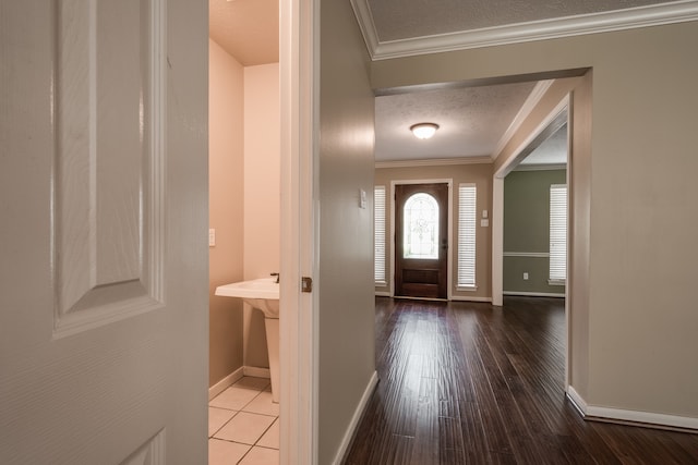 entrance foyer with a textured ceiling, ornamental molding, and hardwood / wood-style flooring