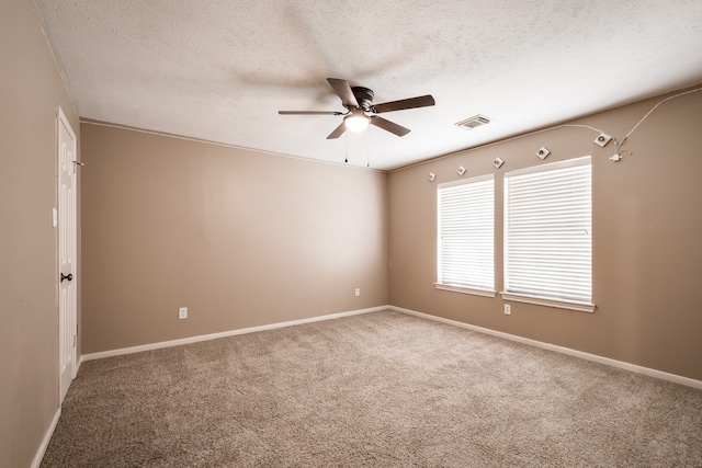 carpeted spare room featuring ceiling fan and a textured ceiling