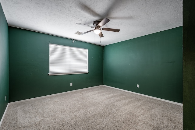 spare room with a textured ceiling, carpet flooring, and ceiling fan