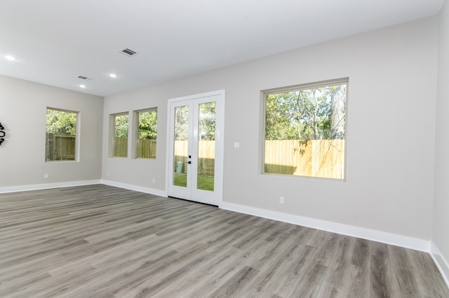 empty room featuring french doors and light hardwood / wood-style floors