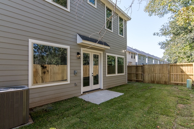 back of house featuring a lawn and central AC unit