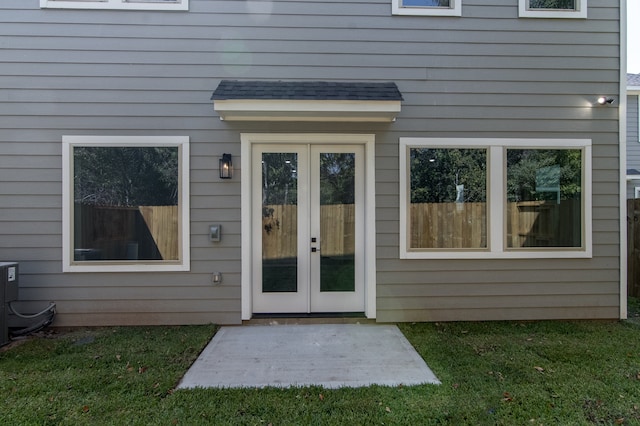 property entrance featuring a lawn and french doors