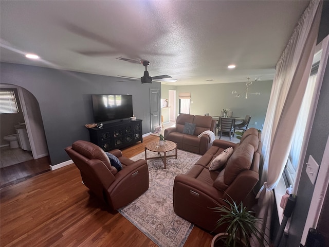 living room with wood-type flooring, ceiling fan, and a textured ceiling