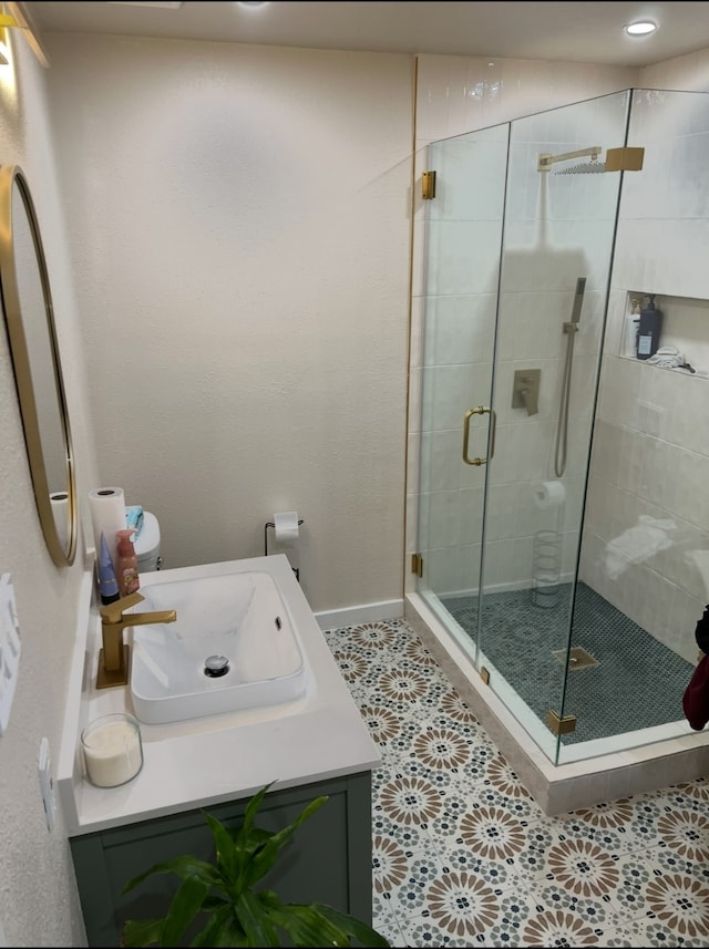 bathroom with walk in shower, vanity, and tile patterned floors