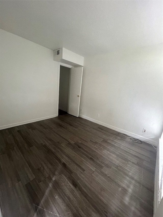 unfurnished room with dark hardwood / wood-style flooring