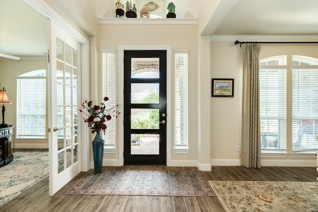 entryway featuring ornamental molding, dark wood-type flooring, and french doors