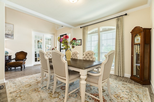 dining space with wood-type flooring and crown molding