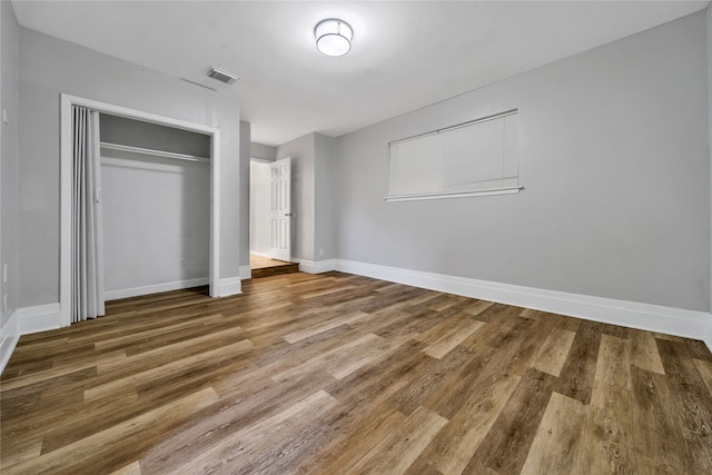 unfurnished bedroom featuring hardwood / wood-style floors and a closet