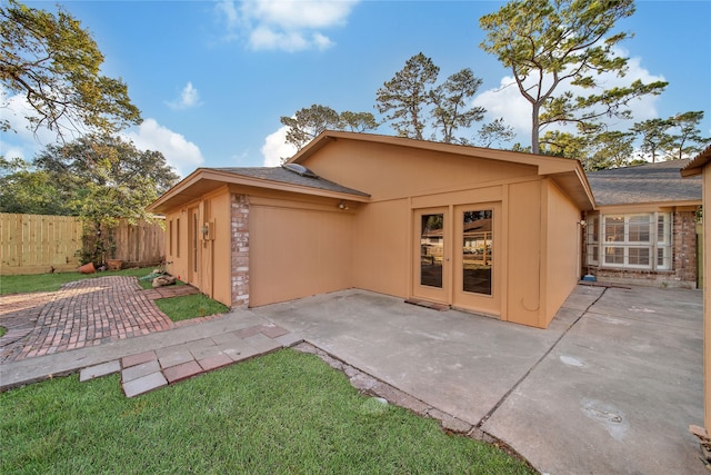 back of house with a patio area and a yard