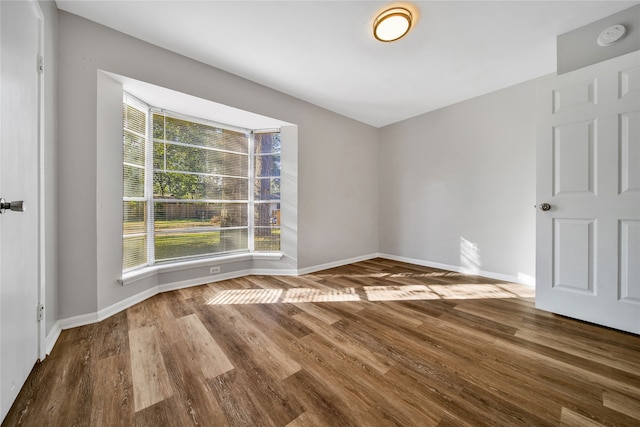 unfurnished room with hardwood / wood-style floors