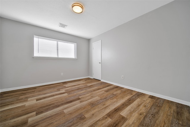 unfurnished room with hardwood / wood-style flooring