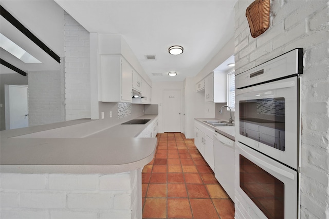 kitchen featuring white cabinets, sink, kitchen peninsula, and white appliances