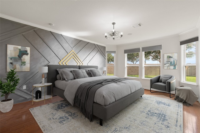 bedroom featuring hardwood / wood-style flooring, wooden walls, crown molding, and a chandelier