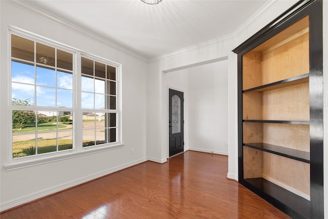 empty room with ornamental molding, dark hardwood / wood-style flooring, and a wealth of natural light