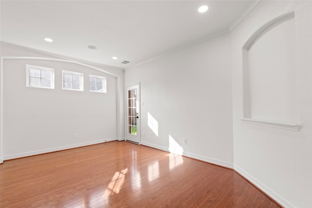 unfurnished room with light wood-type flooring and ornamental molding