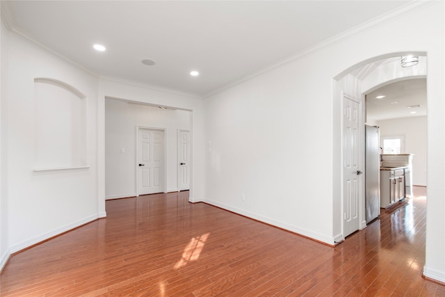 spare room with crown molding and dark wood-type flooring