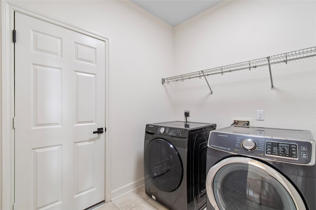 laundry area with separate washer and dryer and light tile patterned flooring