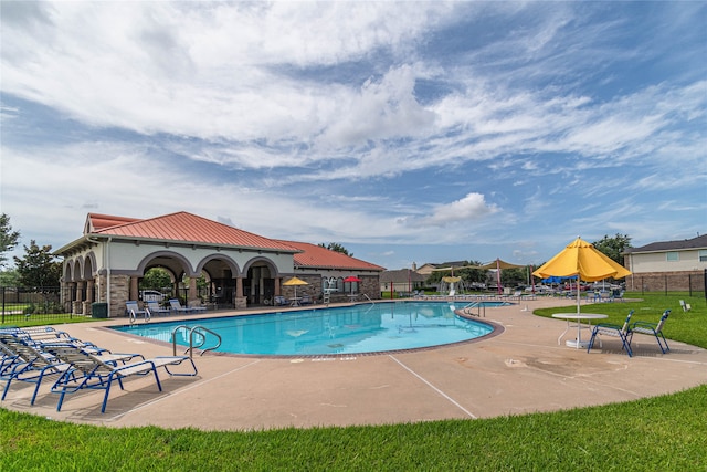 view of pool featuring a patio and a yard