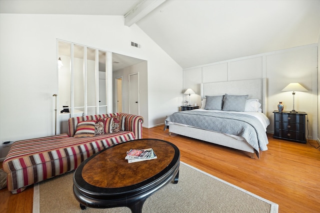 bedroom featuring lofted ceiling with beams and wood-type flooring