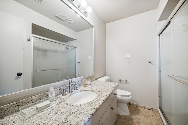 bathroom featuring vanity, toilet, and a shower with door