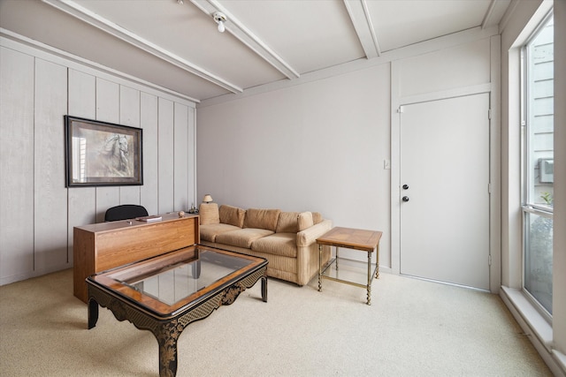 carpeted living room with beamed ceiling