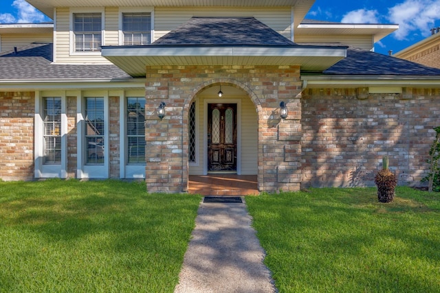 view of exterior entry featuring a yard