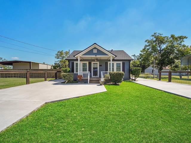 view of front of home with a porch, a front yard, concrete driveway, and fence
