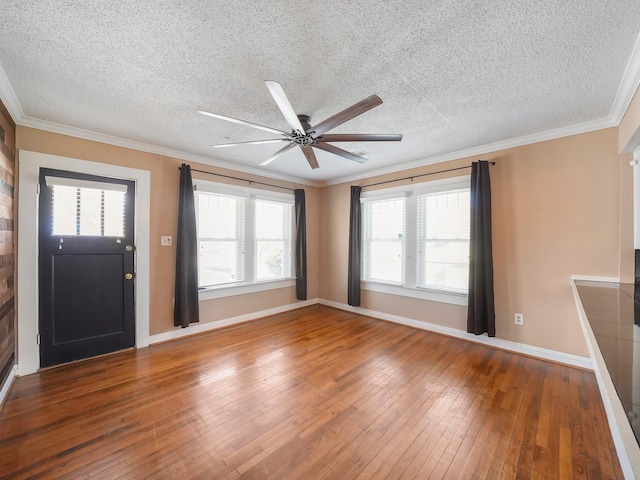 foyer with a textured ceiling, hardwood / wood-style flooring, baseboards, ornamental molding, and a ceiling fan