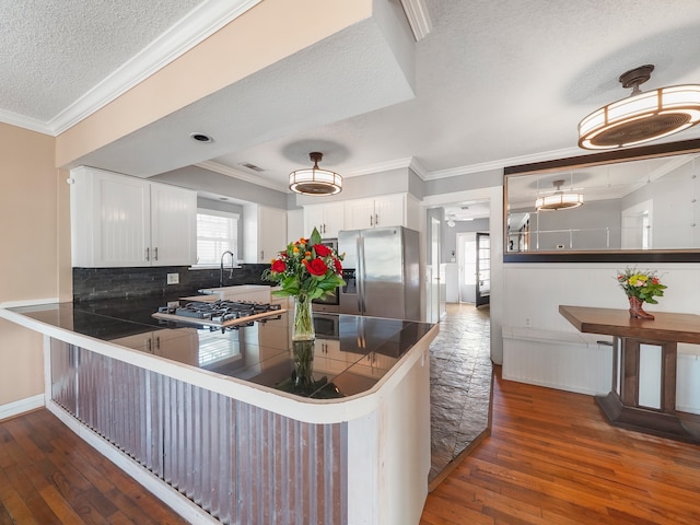 kitchen with a textured ceiling, white cabinetry, stainless steel appliances, backsplash, and dark hardwood / wood-style flooring