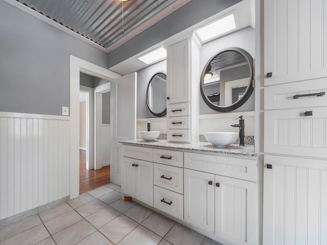 bathroom featuring vanity, a skylight, and tile patterned floors