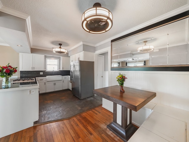 kitchen with white cabinetry, dark wood-type flooring, a textured ceiling, stainless steel refrigerator with ice dispenser, and sink