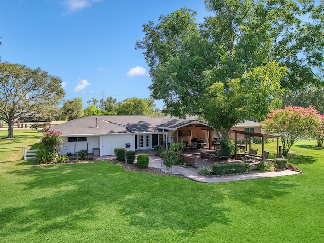 back of property with a lawn, fence, a patio, and french doors