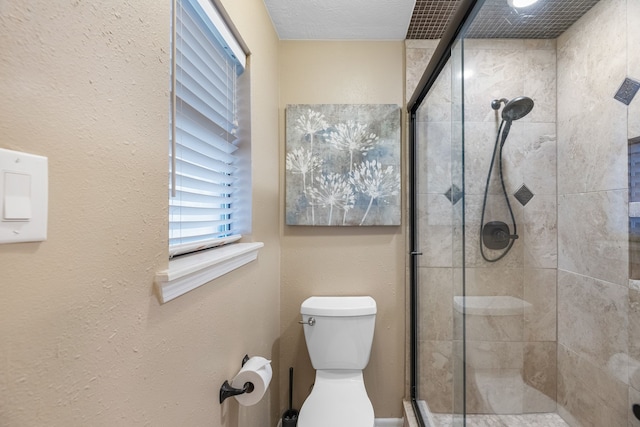 bathroom featuring toilet and a shower with door