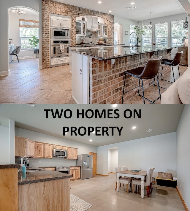 kitchen featuring a wealth of natural light, a spacious island, sink, and appliances with stainless steel finishes