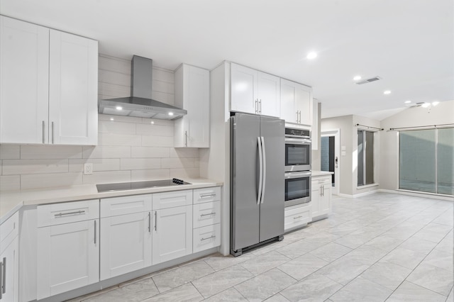 kitchen featuring white cabinetry, wall chimney range hood, stainless steel appliances, and tasteful backsplash