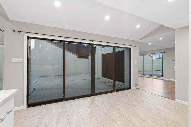 unfurnished room featuring lofted ceiling and light wood-type flooring